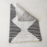 Textured rug with black and white pattern on a light gray background
