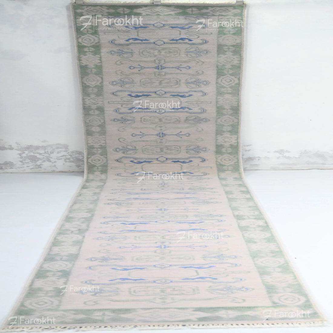 Decorative rug with a geometric pattern on a white background, branded &