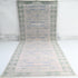 Decorative rug with a geometric pattern on a white background, branded &