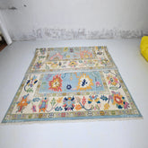 Colorful patterned rug on a white floor with a textured wall background